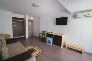 a living room with a couch and a tv at Hotel Venus in Mamaia