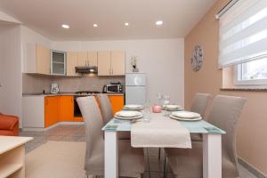 cocina y comedor con mesa y sillas en Apartments La Natalli, en Baška