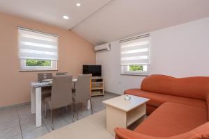 a living room with a couch and a table at Apartments La Natalli in Baška