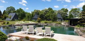 a group of chairs sitting on a deck next to a lake at Zen Garden Resort, Zánka in Zánka