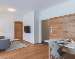 uma sala de estar com uma mesa e cadeiras e uma televisão em Appartement Almblick em Brixen im Thale
