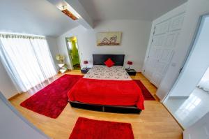 a bedroom with a red bed with a red blanket at Apartamentos 7 Saias Marginal in Nazaré
