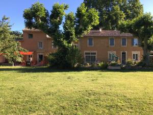 a large house with a yard in front of it at Désir'ôôm in Cabannes