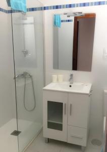 ein weißes Bad mit einem Waschbecken und einer Dusche in der Unterkunft Apartamentos Sirena in Mogán
