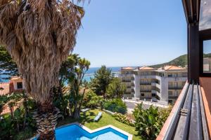 a view of the pool from the balcony of a hotel at RENT4REST Sesimbra 4Bdr Ocean View and Private Pool Villa in Sesimbra