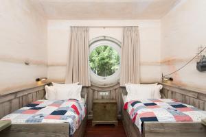 2 Betten in einem Zimmer mit Fenster in der Unterkunft Hotel Fährhaus in Munkmarsch