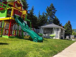 a playground in front of a house with a slide at Tu Urlop in Mielno +24 photos