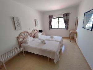sypialnia z 2 łóżkami i oknem w obiekcie DUNAS DO ALVOR by LTS Holidays - #127 w Alvor