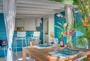a dining room with a wooden table and blue walls at Complexe de deux bungalows de standing in Case-Pilote