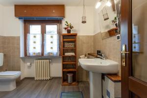CharvensodにあるBondine Apartments in Valle d'Aostaのバスルーム(洗面台、トイレ付)、窓が備わります。
