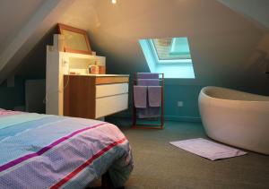 sypialnia z łóżkiem, wanną i oknem w obiekcie Montreuil Appart Holidays w mieście Montreuil-sur-Mer