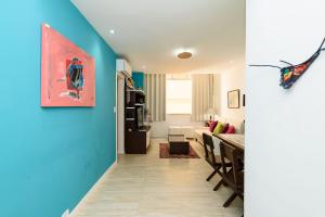 里約熱內盧的住宿－Apartamento em Ipanema perto da praia | PM1441/206，一间拥有蓝色墙壁的客厅和一间餐厅