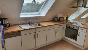 een keuken met een wastafel en een raam bij Ferienwohnung mit See- und Waldblick in Möhnesee