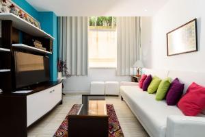 a living room with a white couch with colorful pillows at Apartamento em Ipanema perto da praia | PM1441/206 in Rio de Janeiro