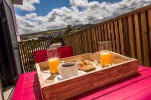 a wooden tray with a plate of food and orange juice at La Case Maui in La Saline les Bains