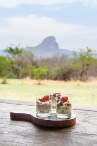 two glasses of dessert on a wooden table at Legend Golf and Safari Resort in Sterkrivier
