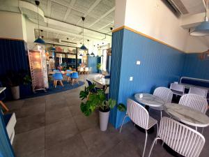 an empty restaurant with two tables and chairs at Apartament PLUS 22 C in Sarbinowo