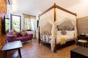 - une chambre avec un lit à baldaquin et un canapé dans l'établissement Hometown B&B, à Hualien