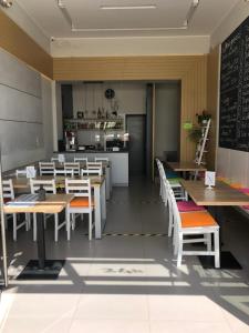 a restaurant with tables and chairs and a kitchen at Hotel City in Gniezno