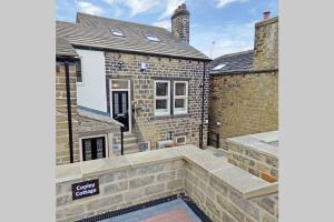 a brick house with a swimming pool in front of it at Copley Loft 3 Bedroom House with Patio in Shepley