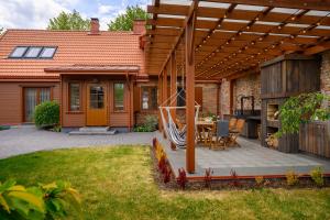 eine Außenterrasse mit einer hölzernen Pergola in der Unterkunft Villa Louis in Ventspils