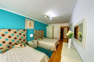 una camera da letto con due letti e una parete blu di Apartamentos 7 Saias - Centro a Nazaré