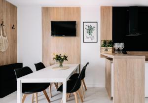 jadalnia z białym stołem i czarnymi krzesłami w obiekcie SeaSide Apartment w Rowach