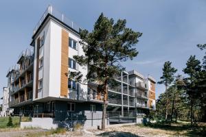 apartamentowiec z drzewem przed nim w obiekcie SeaSide Apartment w Rowach