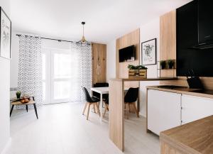 cocina y comedor con mesa y sillas en SeaSide Apartment, en Rowy