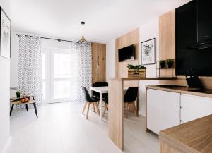 a kitchen and dining room with a table and chairs at SeaSide Apartment in Rowy