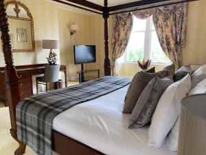 a bedroom with a bed and a desk and a television at Boat Country Inn and Restaurant in Boat of Garten