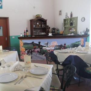 uma sala de jantar com duas mesas com pratos brancos em Segesta Antichi Sapori em Calatafimi