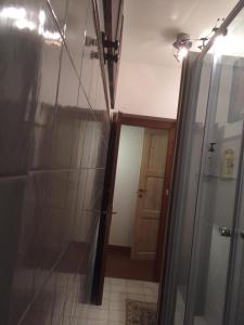 a bathroom with a glass shower and a door at Stenghe Stracche 2 in Ascoli Piceno