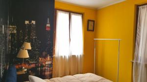 a yellow room with a window with a view of a city at Stenghe Stracche 2 in Ascoli Piceno