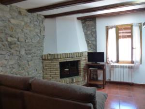 a living room with a couch and a stone fireplace at Casa Altemir in Campo