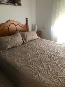 sypialnia z dużym łóżkiem z drewnianym zagłówkiem w obiekcie apto Fradera w mieście La Savina