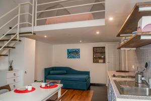 a living room with a blue couch and a kitchen at Belmar in Gaeta