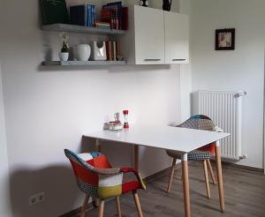 - une table et des chaises blanches dans la chambre dans l'établissement Ferienwohnung am Schweriner See, à Schwerin