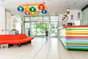 a lobby with a colorful couch and a store at Hotel Euro in Pardubice