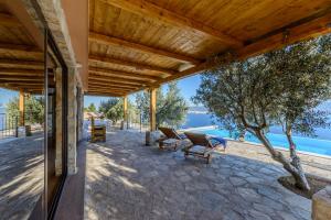 een patio met banken en uitzicht op het water bij Villa Secluded Paradise in Omiš