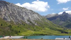 a mountain with a lake in front of it at Studio 50 m du funiculaire et pistes in Tignes