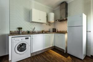 een witte keuken met een wasmachine en een koelkast bij APARTAMENTO BOLONIA SUR A in Bolonia