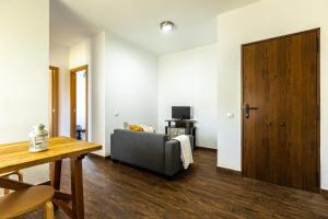 a living room with a couch and a wooden door at APARTAMENTO BOLONIA SUR A in Bolonia