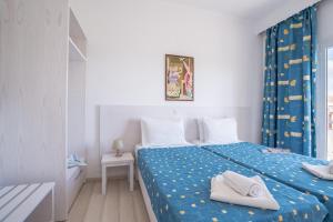 een slaapkamer met een bed met twee handdoeken erop bij Dimitra Apartments G in Gouvia