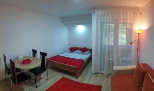 1 dormitorio con cama y mesa y 1 habitación con mesa en Apartman 4 - Studio Janja, en Soko Banja