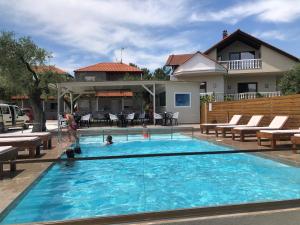 a swimming pool with chairs and a house at Studios River in Potos