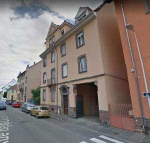 a building on a street with cars parked in front of it at la lauch in Colmar