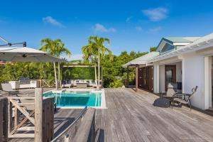 a wooden deck with a pool and a house at Dream Villa Gouverneur 655 in Saint Barthelemy