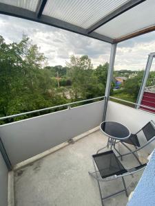 eine Terrasse mit 2 Stühlen und einem Tisch auf dem Balkon in der Unterkunft Gästeapartement Markkleeberg in Markkleeberg