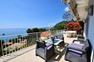 a balcony with chairs and a table and the ocean at Villa piscine Eze bord de mer à 500m de la plage in Èze